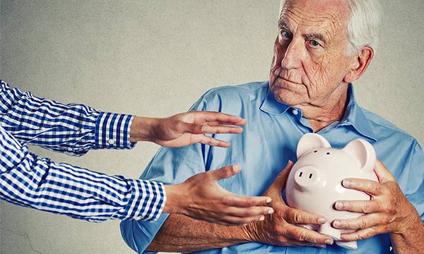 A younger man trying to steal a senior man's piggybank as he clutches it.