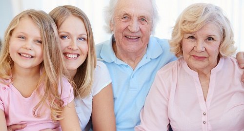 Three generations of a family smiling for a photo.