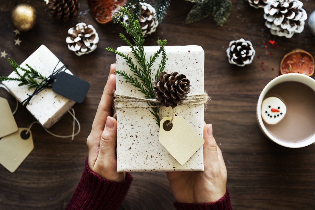 A senior holding a tastefully-wrapped Christmas gift.