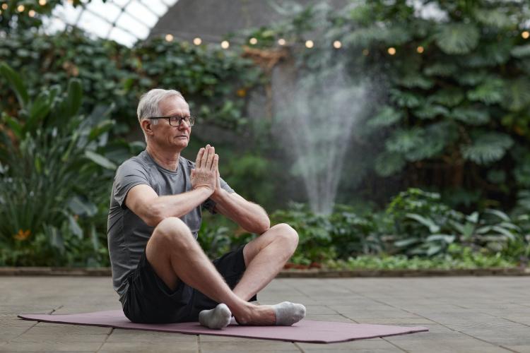 Photograph of a senior man doing yoga.