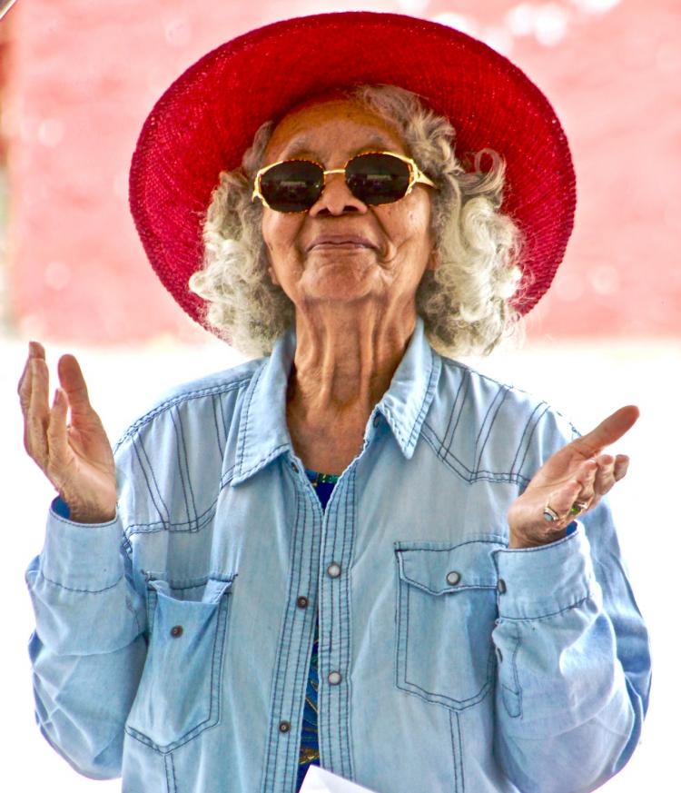 A senior woman wearing a red hat.