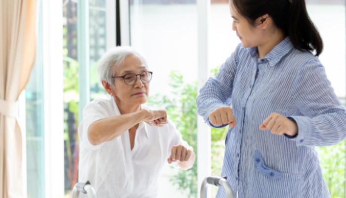 A senior exercising with a caregiver.